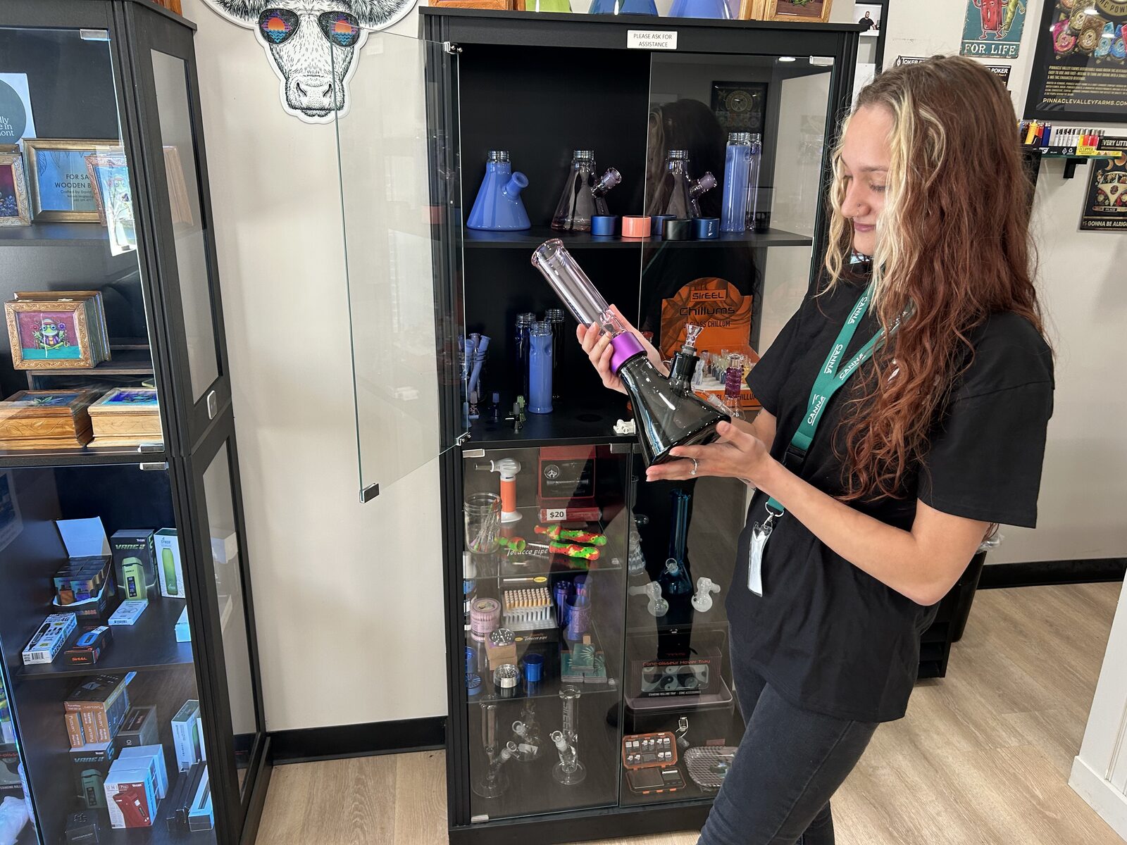 A team member holding up a glass piece in front of the lit display cases